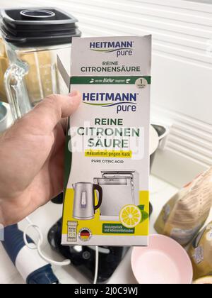 Karlsruhe, Allemagne - 13 mars 2022 : gros plan de la main d'homme tenant Heitmann Pure détartrant pour les appareils de cuisine. Détartrez une bouilloire à thé, enlevez le calcaire pour de l'eau propre dans la bouilloire, lave-vaisselle, etc Banque D'Images