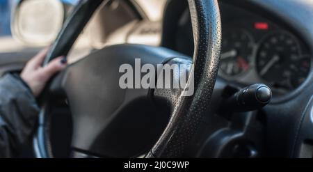 Gros plan de la main de femme sur le volant de direction en conduisant la voiture Banque D'Images