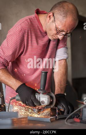 Rectification électrique des roues sur structure en acier en usine. Étincelles de la meule Banque D'Images