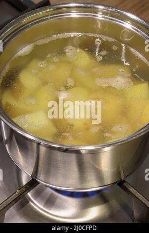 Gros plan d'une casserole en acier inoxydable avec des pommes de terre bouchées sur une table de cuisson Banque D'Images