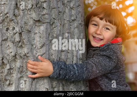 Enfant hug arbre protection de l'environnement amour nature conservation à l'extérieur nature embrassant Banque D'Images