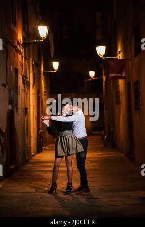 Couple parfait dans l'amour embrassant, dansant dans une rue de ville la nuit. Banque D'Images