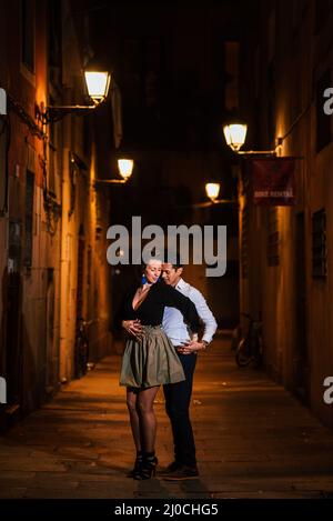 Couple parfait dans l'amour embrassant, dansant dans une rue de ville la nuit. Banque D'Images