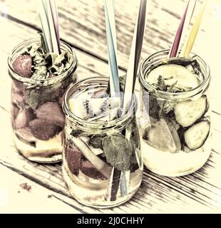 Une variété de boissons froides en petites bouteilles avec morceaux de fruits fond de bois Banque D'Images