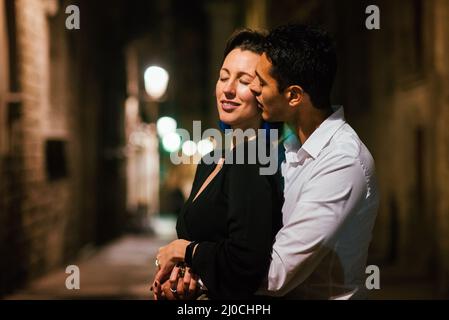 Couple parfait dans l'amour embrassant, dansant dans une rue de ville la nuit. Banque D'Images