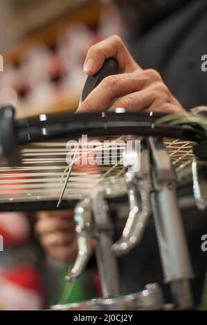 Machine à élingage. Détail des mains de la stringer de tennis tout en tenant l'auge et en faisant la racket de raquette Banque D'Images