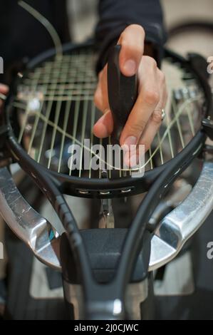 Machine à élingage. Détail des mains de la stringer de tennis tout en tenant l'auge et en faisant la racket de raquette Banque D'Images
