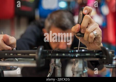 Machine à élingage. Détail des mains de la stringer de tennis tout en tenant l'auge et en faisant la racket de raquette Banque D'Images