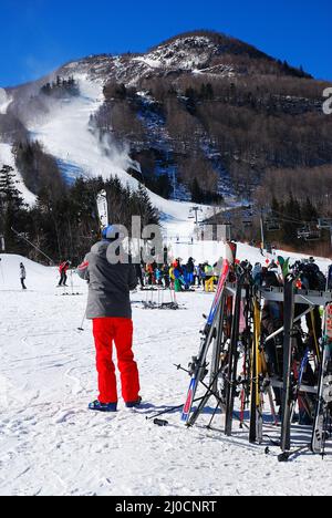 Un skieur prend ses skis de la crémaillère comme il est prêt à prendre sur les pistes Banque D'Images