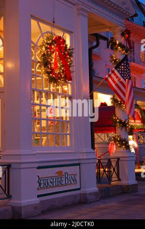 Une couronne est suspendue sur une fenêtre de banque, illuminée pour Noël, à Stockbridge, Massachusetts Banque D'Images