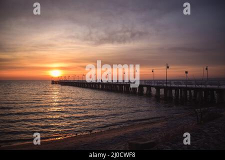 Paysage matinal coloré en bord de mer. Jetée en bois sur la mer au lever du soleil. Banque D'Images