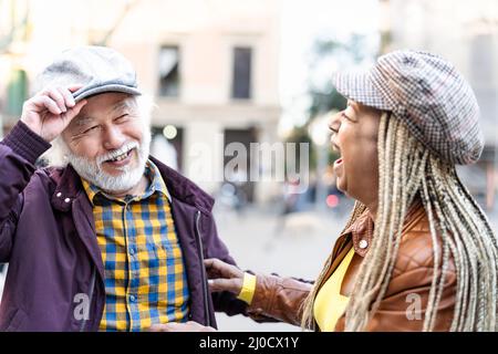 Joyeux couple multiracial senior s'amusant en ville - personnes âgées et concept de relation d'amour Banque D'Images