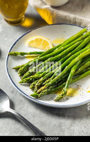 Asperges biologiques faites maison à la vapeur avec du citron et de l'huile d'olive Banque D'Images