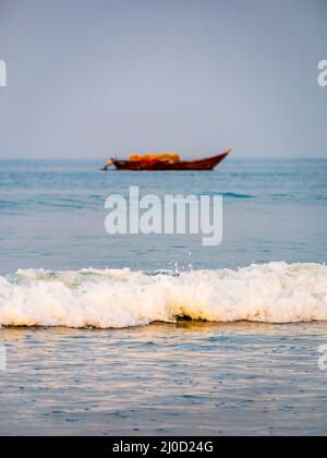 Vagues de la mer d'Arabie avec bateau de pêcheur vide en arrière-plan Banque D'Images