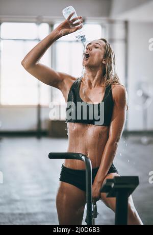 Oui, je l'ai tué. Photo d'une jeune femme qui verse de l'eau sur son visage après un entraînement sérieux. Banque D'Images