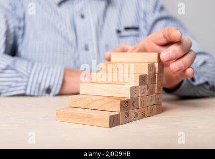 Homme d'affaires main bâtiment échelle de carrière à partir de blocs de bois. Développement des affaires, planification stratégique, concept de croissance professionnelle. Photo de haute qualité Banque D'Images