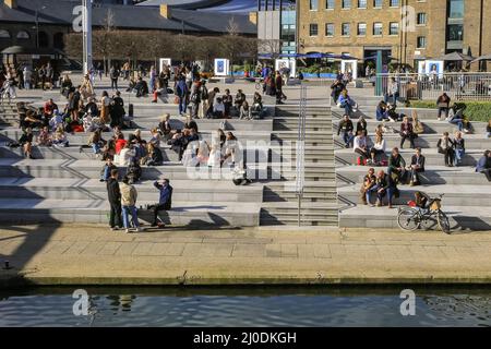 Londres, Royaume-Uni. 18th mars 2022. Les gens de la place Granary de Londres bronzer au bord du canal. La capitale a connu une journée bien ensoleillée avec des températures allant jusqu'à 17 degrés et un ciel bleu clair tout au long de la journée. Credit: Imagetraceur/Alamy Live News Banque D'Images