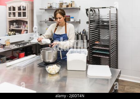 Faire cuire la farine dans un grand bol en aluminium Banque D'Images