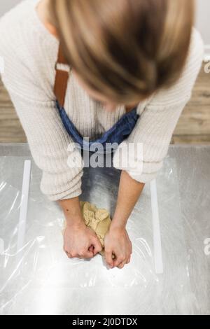 Femme anonyme pétriant la pâte pour la pâtisserie dans la boulangerie Banque D'Images