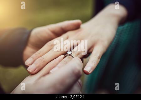 Pour toujours est long, mais pas assez long avec vous. Plan court d'un homme mettant un anneau d'engagement sur son doigt de fiancé à l'extérieur. Banque D'Images