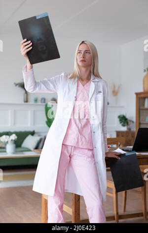 Femme médecin regardant les rayons X dans le bureau. Banque D'Images