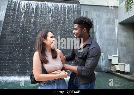 Des amis souriants de différentes origines ethniques se tenant et parlant dans un centre commercial Banque D'Images