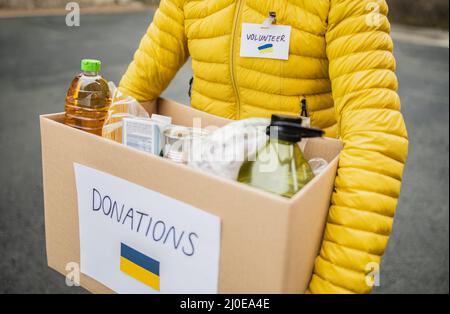 Volontaire collecte de boîte avec des dons pour les réfugiés ukrainiens - aide humanitaire pour Ukrania Banque D'Images
