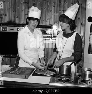 Prudence Leith (également connue sous le nom de Prue Leith) photographié À GAUCHE dans la chemise blanche sous son tablier blanc, avec Caroline Waldergrave photographiée À DROITE avec sa chemise noire sous son tablier blanc. Prue et Caroline sont les auteurs d'un nouveau livre de cuisine - Leith's Cookery course Book 1 - et sont vus se préparant ce soir à l'arrivée de l'un de leurs cours de cuisine du soir à arriver. Photo prise le 24th octobre 1979 Banque D'Images