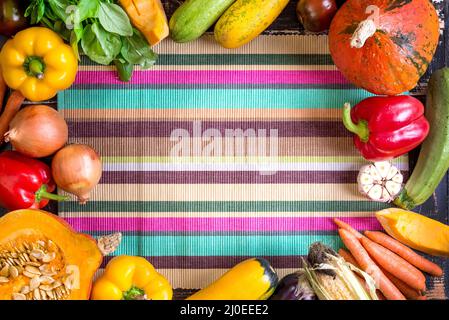 Légumes frais sur une serviette de cuisine à rayures colorées. Automne fond Banque D'Images