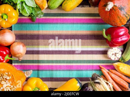 Légumes frais sur une serviette de cuisine à rayures colorées. Automne fond Banque D'Images