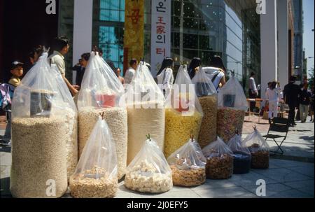 Des sacs géants avec des craquelins de riz dans un stand en plein air sur un trottoir dans une rue commerçante de Séoul. Banque D'Images