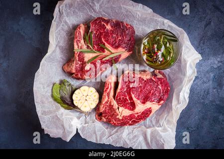 Les viandes steak sur un papier cuisson prêt à rôtir Banque D'Images