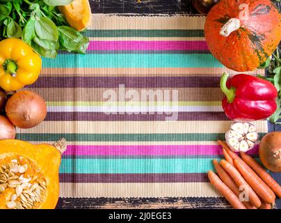 Légumes frais sur une serviette de cuisine à rayures colorées. Automne fond Banque D'Images