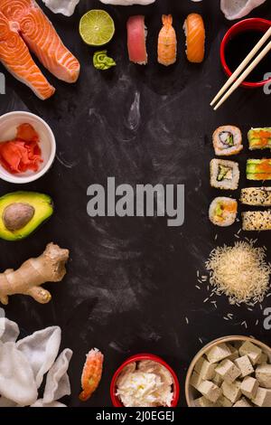 Des sushis et des ingrédients sur fond sombre Banque D'Images
