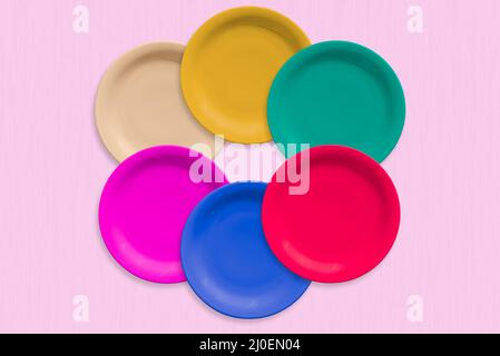 Plaques rondes en céramique de couleur sur fond rose Banque D'Images