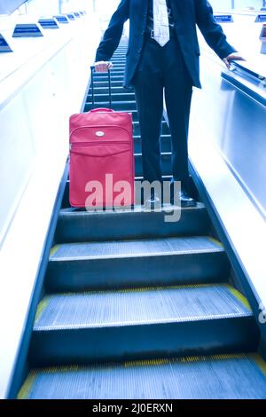 Homme d'affaires qui descend dans un escalator Banque D'Images