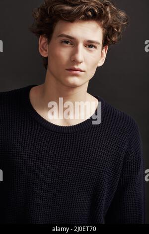 Sage au-delà de ses années. Portrait d'un jeune homme frais portant des vêtements d'hiver et posant en studio. Banque D'Images