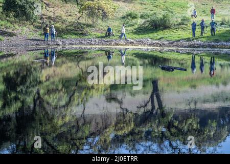 Un groupe de randonneurs appréciant le plein air et regardant les jolis reflets dans l'eau dans la campagne du nord de la Californie. Banque D'Images