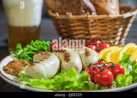 Appétissant saucisses de poulet grillées sur une assiette de légumes Banque D'Images