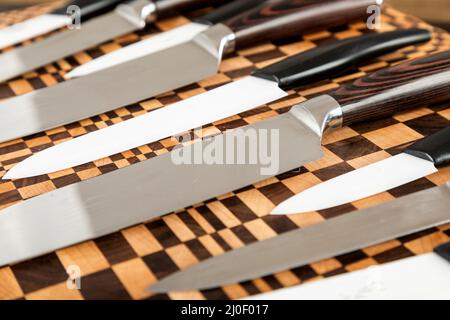 Un ensemble de couteaux de cuisine de haute qualité sur une planche à découper Banque D'Images