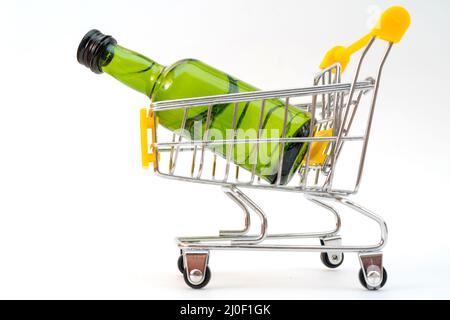 Vendre de l'alcool dans un magasin. Bouteille verte dans un chariot de supermarché. Buvez dans une bouteille verte. Banque D'Images