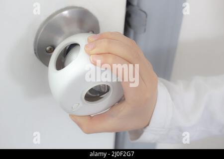 La manette de porte anti-enfants Recouvre le bouton de la porte avec une main pour enfant qui tente d'ouvrir la porte Banque D'Images