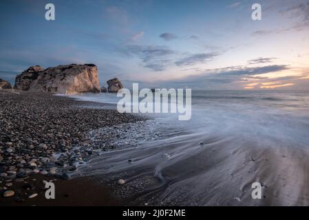 Vue sur la mer avec vagues venteuses et ciel nuageux au coucher du soleil. Rocher d'Aphrodite, Paphos Chypre Banque D'Images