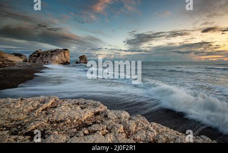 Paysage de mer avec vagues venteuses et ciel d'humeur sombre au coucher du soleil, Paphos Chypre Banque D'Images