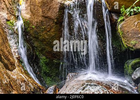 Petite cascade entre les pierres Banque D'Images