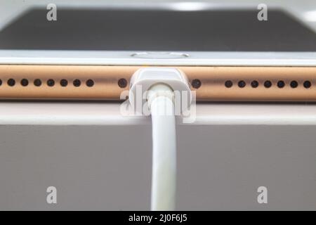 Calgary, Alberta. Canada le 5 juillet 2020. Vue macro d'un iPhone plus en charge avec un câble USB Lightning. Banque D'Images