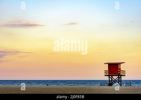 Cabine de sauvetage sur la plage au coucher du soleil tropical Banque D'Images