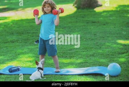 Enfant sportif avec haltères.Sport et fitness, santé et énergie pour les enfants.Un mode de vie sain pour les enfants.Gai garçon faire des exercices avec des haltères.Sport Banque D'Images