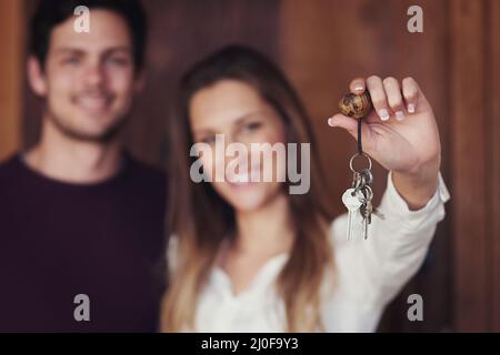 Les clés de notre maison douce maison. Portrait d'un jeune couple tenant les clés de leur nouvelle maison. Banque D'Images