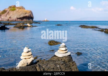 Pyramide de galets blancs d'équilibrage, sur le rocher d'une plage rocheuse Banque D'Images